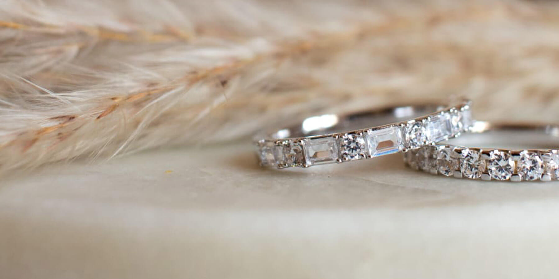 Two diamond rings on a textured surface with a blurred background