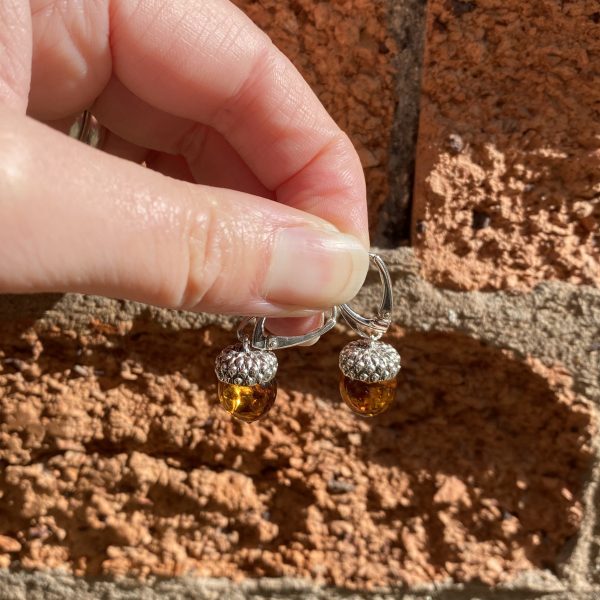 amber acorn earrings against brick